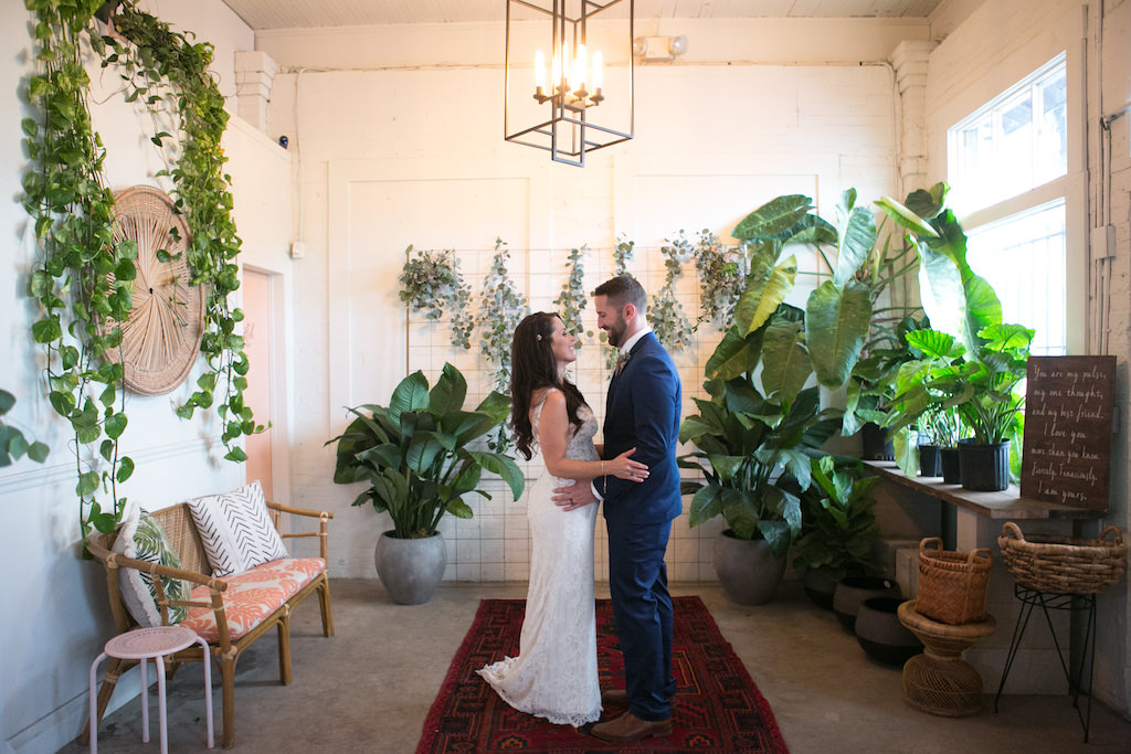 Indoor Bride and Groom Wedding Portrait, Bride Wearing V-Neck Lace Floor Length Wedding Dress, Curled Hair Down with Jeweled Hair Clip, Groom Wearing Navy Blue Suit | Tampa Bay Wedding Photographer Carrie Wildes Photography | Tampa Heights Wedding Venue Fancy Free Nursery