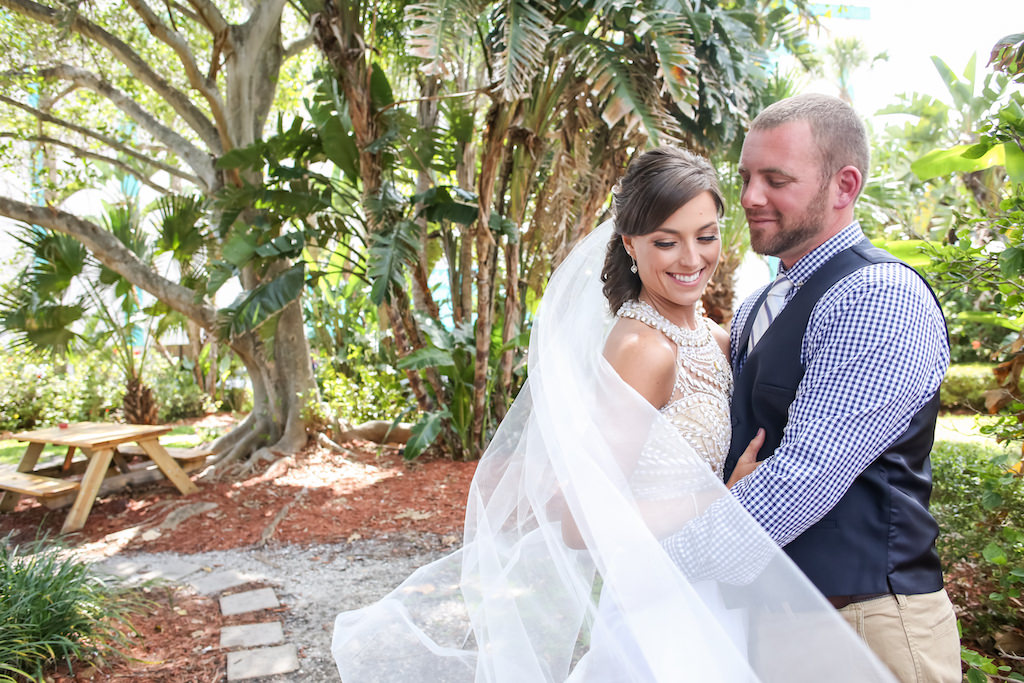 Outdoor Bride and Groom First Look Creative Portrait A-Line Scoop Neck Nude Rhinestone Bodice and White Chiffon Floor Length Wedding Dress with Beaded Keyhole Back and Cathedral Veil and Curled Half Up Hairdo and Neutral Makeup, Groom Wearing Khaki Pants, Blue and White Checkered Dress Shirt, Navy Blue Vest and White and Blue Striped Tie | Tampa Bay Wedding Photographer Lifelong Photography Studios | Tampa Bay Wedding Hair and Makeup Michele Renee the Studio
