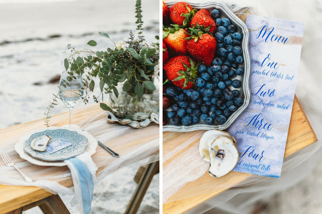 Waterfront Coastal Sandy White Redington Shores Wedding Reception Decor, Long Wooden Table with Decorative Blue Plate, Tulle and Blue Ribbon Linens, Greenery in Glass Vase | Blueberry and Strawberries on Silver Platter, Custom Coastal Watercolor Blue Menu and Oyster Shells