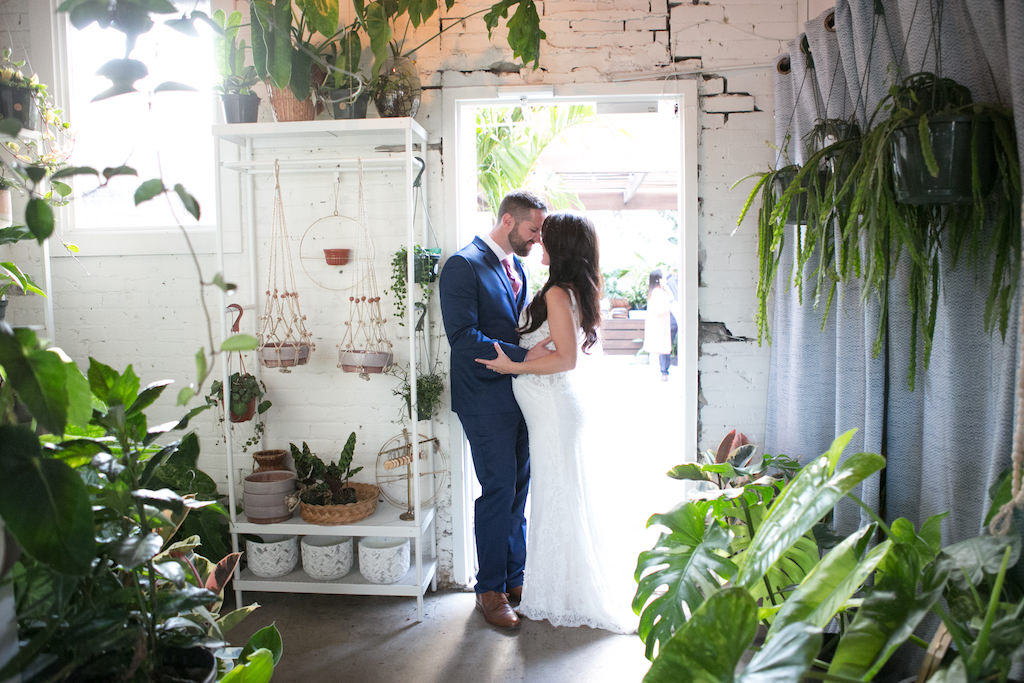 Indoor Bride and Groom Wedding Portrait, Bride Wearing V-Neck Lace Floor Length Wedding Dress, Curled Hair Down, Groom Wearing Navy Blue Suit and Red Tie | Tampa Bay Wedding Photographer Carrie Wildes Photography | Downtown Tampa Wedding Venue Fancy Free Nursery