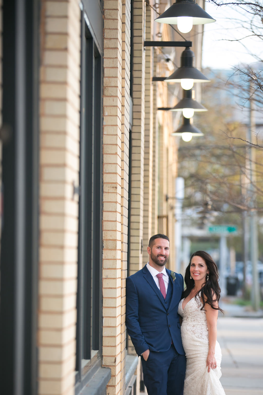 Outdoor Bride and Groom Wedding Portrait, Bride Wearing V-Neck Lace Floor Length Wedding Dress, Curled Hair Down, Groom Wearing Navy Blue Suit and Red Tie | Tampa Bay Wedding Photographer Carrie Wildes Photography