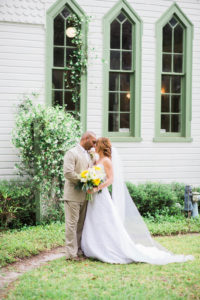 Outdoor Bride and Groom Portrait, Bride in Sweetheart Strapless Lace A-Line Wedding Dress and Veil with White Daisy, Yellow Sunflower and Greenery Floral Bouquet, Groom in Tan Suit | Tampa Bay Wedding Venue Andrews Memorial Chapel