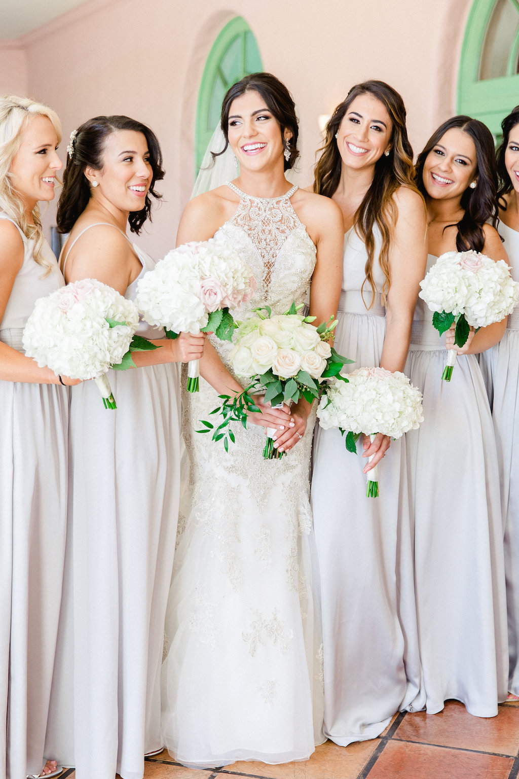 Bride and Bridesmaids Wedding Portrait in High Halter Lace and Rhinestone Bodice Wedding Dress, and Grey Bridesmaids Dresses with White Floral Bouquets | Tampa Hair and Makeup Artist Femme Akoi | St. Petersburg Photographer Ailyn La Torre Photography