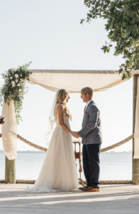 Outdoor Waterfront Bride and Groom Wedding Ceremony Portrait, Arch with White Draping and White and Greenery Bouquet | Tampa Bay Wedding Planner Kelly Kennedy Weddings and Events