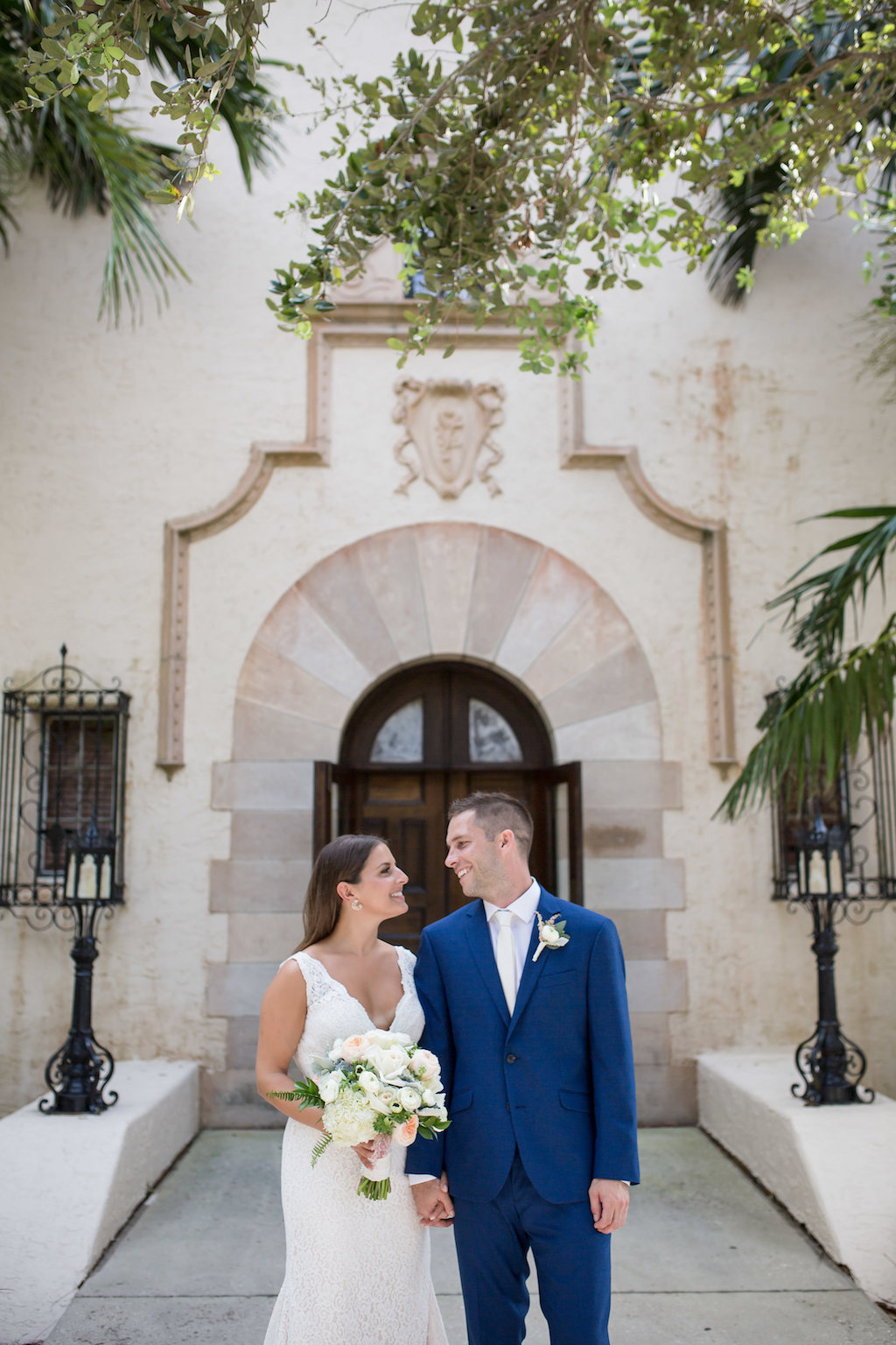 Outdoor Bride and Groom Wedding Portrait, Bride in Lace Tank Top Strap Plunging V Neckline Wedding Dress with White and Blush Pink Floral Bouquet, Groom in Blue Suit with White Tie and White Flower Bouttonniere | Tampa Bay Photographer Cat Pennenga Photography | Sarasota Venue Powel Crosley Estate