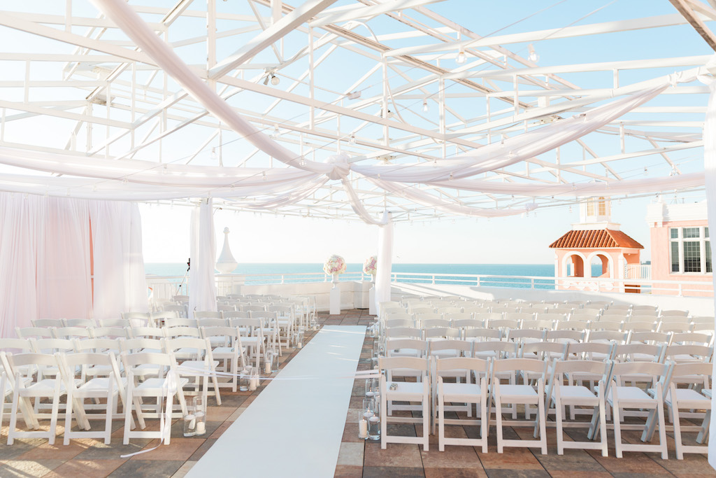Outdoor Waterfront Rooftop Wedding Ceremony, White Folding Chairs, White Aisle Runner, White Draping and White Pedestals with Pink and White Bouquets | Historic St. Petersburg Wedding Venue The Don Cesar