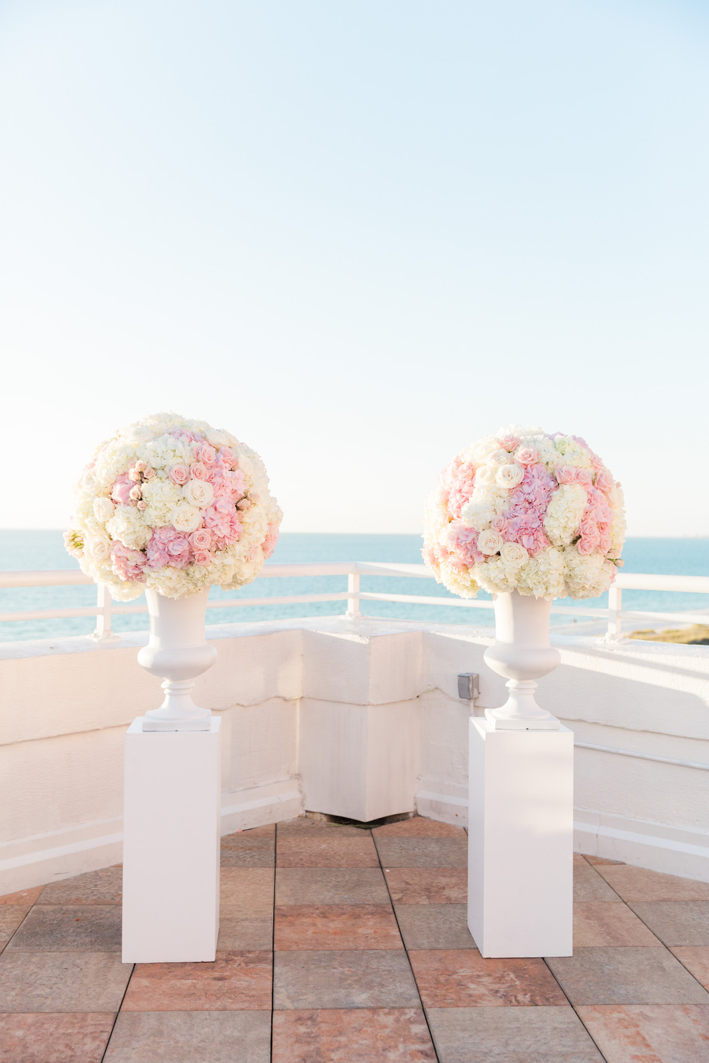 Outdoor Hotel Rooftop Wedding Ceremony Decor, White Pedestals with White Vases and Pink and White Rose Bouquets | St. Petersburg Wedding Venue The Don Cesar