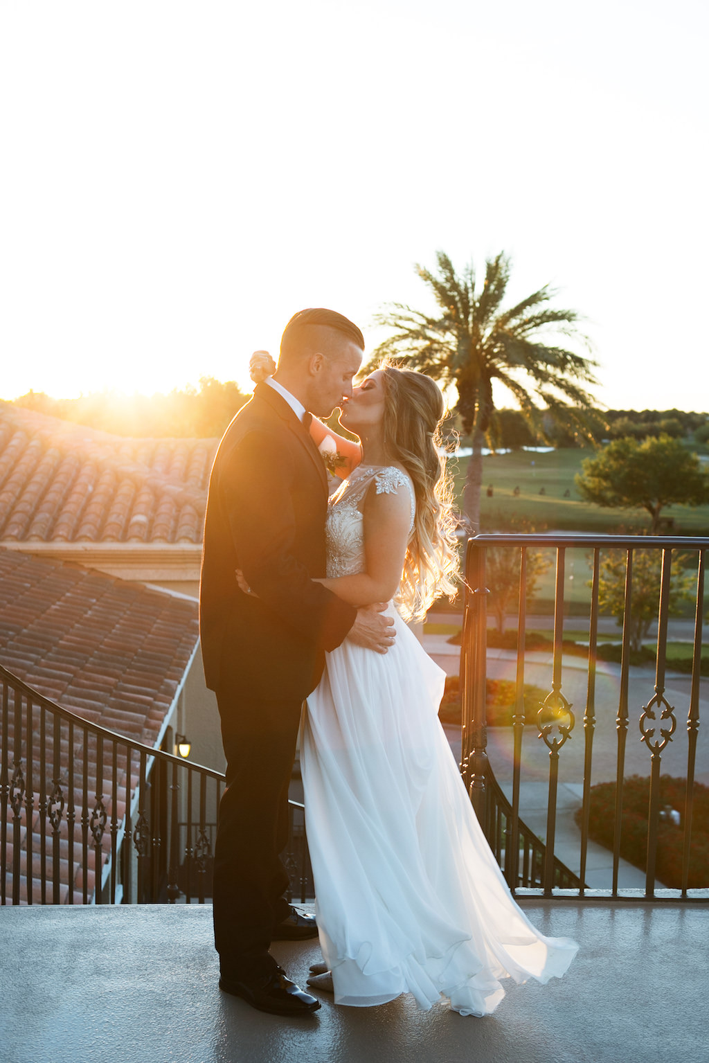 Romantic Outdoor Sunset Bride and Groom Wedding Portrait, Bride in Maggie Sottero Illusion Tank Top with Beaded Lace Motif Wedding Dress with White Rose Bouquet, Groom in Black Tuxedo | Sarasota Wedding Photographer Carrie Wildes Photography | Sarasota Wedding Venue Lakewood Ranch Golf and Country Club