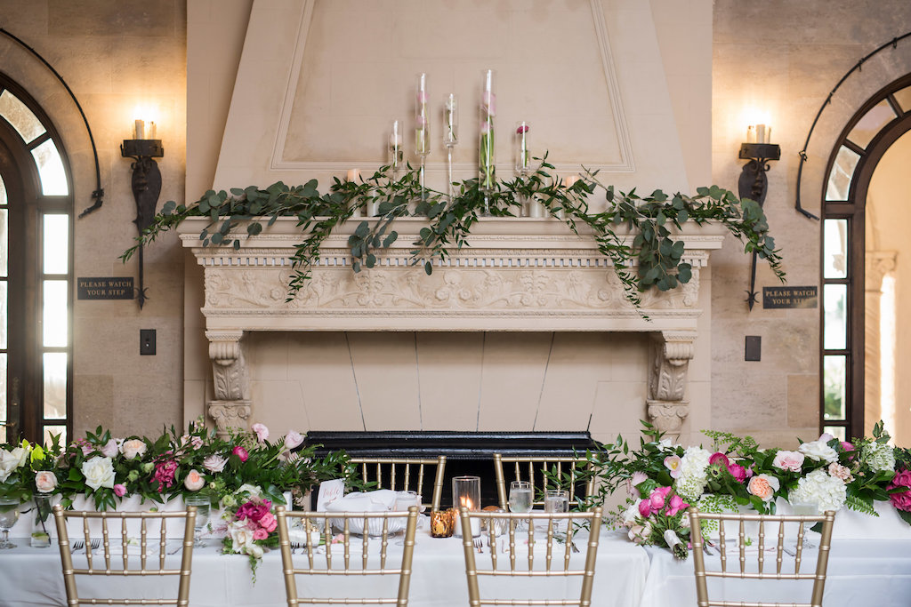 Elegant Wedding Reception Decor, Long Feasting Table with White Tablecloth, Gold Chiavari Chairs, Pink, Blush Pink, White and Greenery Bouquets, Greenery Garland on Fireplace with Floating Candles | Sarasota Wedding Photographer Cat Pennenga Photography