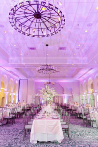 Elegant Ballroom Reception Decor, Long Banquet Table with White Linen and High White Floral Centerpiece, Purple/Pink Uplighting, Silver Chiavari Chairs | Tampa Wedding Photographer Ailyn La Torre | Venue The Vinoy Renaissance St. Petersburg Resort & Golf Club