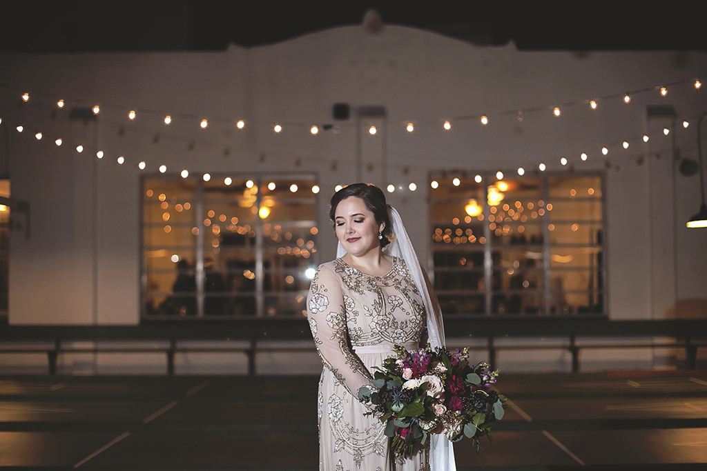 Outdoor Nighttime Bridal Wedding Portrait in Illusion Long Sleeve Cream Floral Beading Embellished Wedding Dress with Satin Belt, Cathedral Length Veil and Fuchsia, Maroon, Blush Pink and Greenery Floral Bouquet | Venue St. Petersburg Shuffleboard Club | Tampa Bay Florist Cotton & Magnolia | Hair and Makeup Femme Akoi