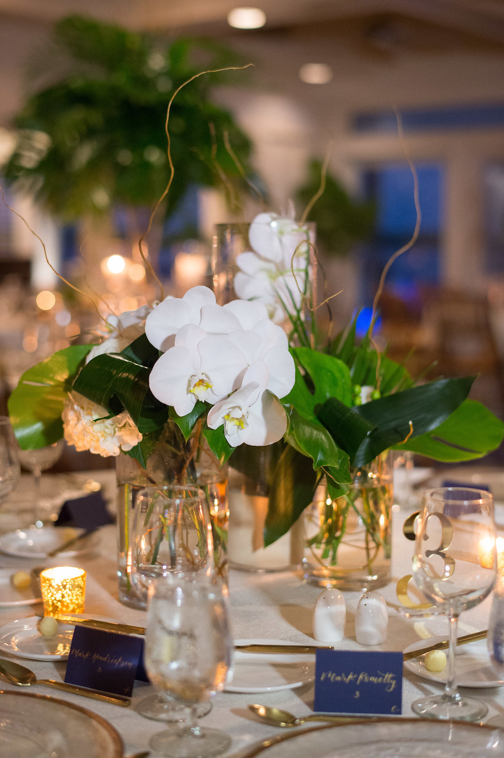 Indoor Wedding Reception Decor, Low Centerpiece with White Orchid Floral and Tropical Greenery Leaves | Tampa Wedding Planner Parties A La Carte | Clearwater Beach Wedding Venue Carlouel Yacht Club | St Pete Rentals Over The Top Linen Rentals