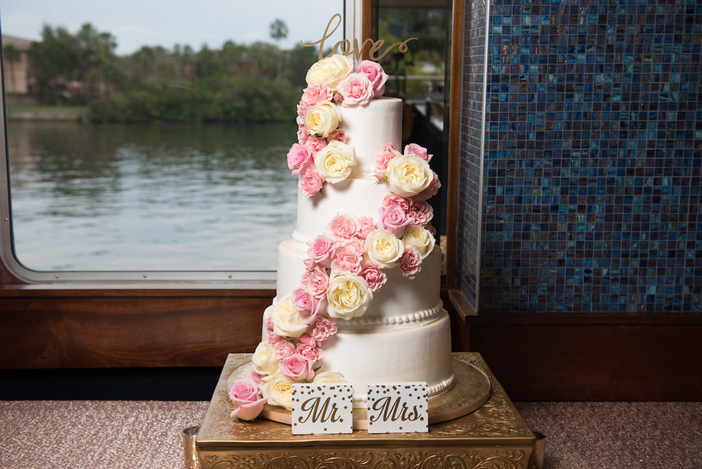 Four Tiered White Simple, Elegant White Wedding Cake with Cascading Pink and Ivory Roses and Lasercut Cake Topper on Vintage Gold Stand with Mrs and Mr Signs | Tampa Bay Waterfront Wedding Venue Yacht Starship | Cake Baker Alessi's Bakery