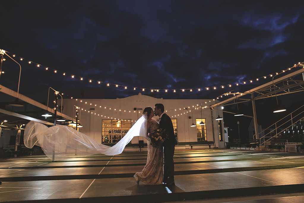 Outdoor Nighttime Creative Bride and Groom Wedding Portrait, Cathedral Length Veil Blowing in the Wind | Wedding Venue St. Petersburg Shuffleboard Club