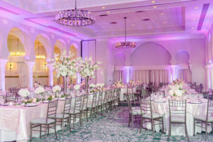 Elegant Ballroom Reception Decor, Long Banquet Table and round Tables with White Linen, High and Low White Floral Centerpieces, Purple/Pink Uplighting, Silver Chiavari Chairs | Tampa Wedding Photographer Ailyn La Torre | Venue The Vinoy Renaissance St. Petersburg Resort & Golf Club