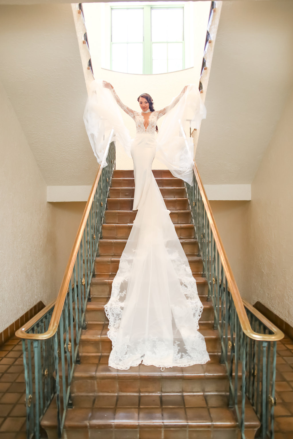 Bridal Portrait on Staircase, Lace and Sheer Long Sleeve Low V-Neck Wedding Dress with Long Train and Veil, Braided Hairstyle | St. Petersburg Photographer Lifelong Photography Studios