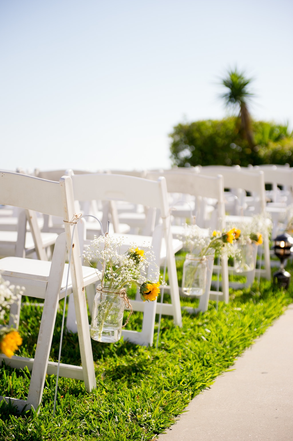 Rustic Outdoor Wedding Ceremony Decor, White Folding Chairs with Hanging Mason Jars, Yellow Sunflowers and Baby's Breathe Florals | Tampa Bay Photographer Andi Diamond Photography