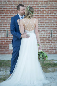 Outdoor Bride Wedding Portrait in A-line Strappy Lace and Tulle Wedding Dress with Greenery, White and Pink Floral Bouquet, Curled Hair Down and Veil, Groom in Navy Blue Suit | Tampa Bay Hair and Makeup Femme Akoi Beauty Studio