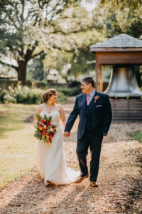 Outdoor Bride and Groom Wedding Portrait, Bride in A-Line Sweetheart Strapless Lace Wedding Dress with Tropical Floral Bouquet, Groom in Navy Blue Suit and Pink Tie | Tampa Bay Photographer Rad Red Creative | Rustic Venue Cross Creek Ranch