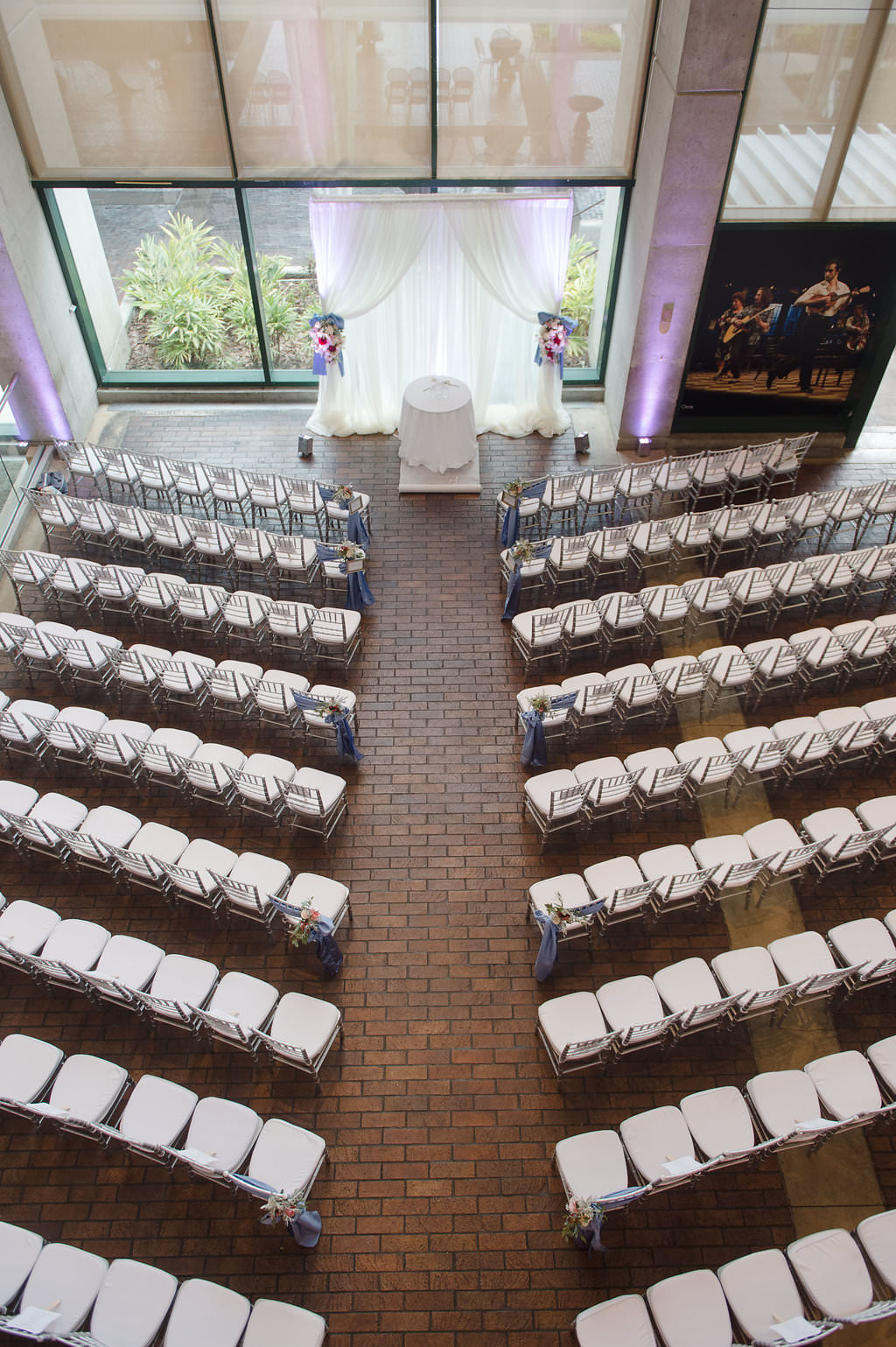 Wedding Ceremony Decor, Silver Chiavari Chairs, Arch with White Draping and Floral Bouquets | Tampa Bay Photographer Marc Edwards Photography | Tampa Venue Straz Center