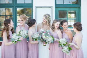 Bride and Bridesmaids Wedding Portrait, Bridesmaids in Dusty Rose Mismatched Dresses with Baby's Breathe Bouquets, Bride in A-line Spaghetti Strap Lace Wedding Dress with Hair Curled Down and Floral Crown Hairpiece | Tampa Bay Hair and Makeup Femme Akoi Beauty Studio
