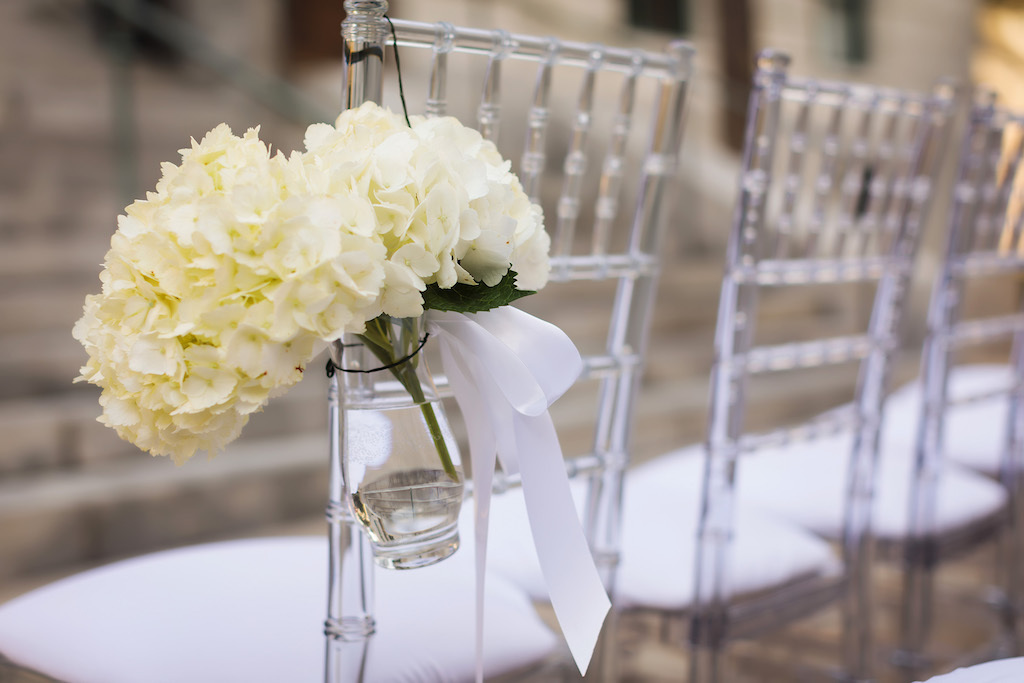 Wedding Ceremony Decor, Clear Acrylic Chiavari Chairs with White Cushions and Glass Vase with White Hydrangea Bouquet | Tampa Kate Ryan Event Rentals
