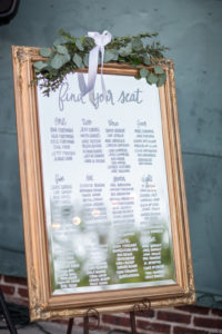 Wedding Reception Seating Chart on Mirror with Gold Frame and Greenery Decor