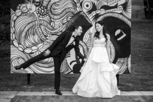 Downtown Tampa Mural Art Creative Outdoor Bride and Groom Wedding Portrait, Bride in Sweetheart Strapless Ballgown Wedding Dress with Rhinestone Belt, Groom in Black Tuxedo and White Floral Boutonniere | Tampa Bay Photographer Marc Edwards Photographs