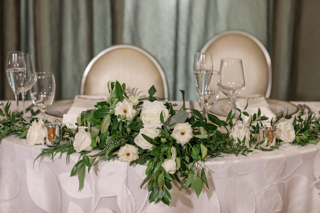 Elegant Ballroom Wedding Reception Decor, Sweetheart Table with White and Greenery Florals, Silver Votives and White Floral Tablecloth | Tampa Bay Photographer Lifelong Photography Studios | Rentals A Chair Affair and Over the Top Rental Linens | Florist Cotton and Magnolia | Planner Parties A'la Carte