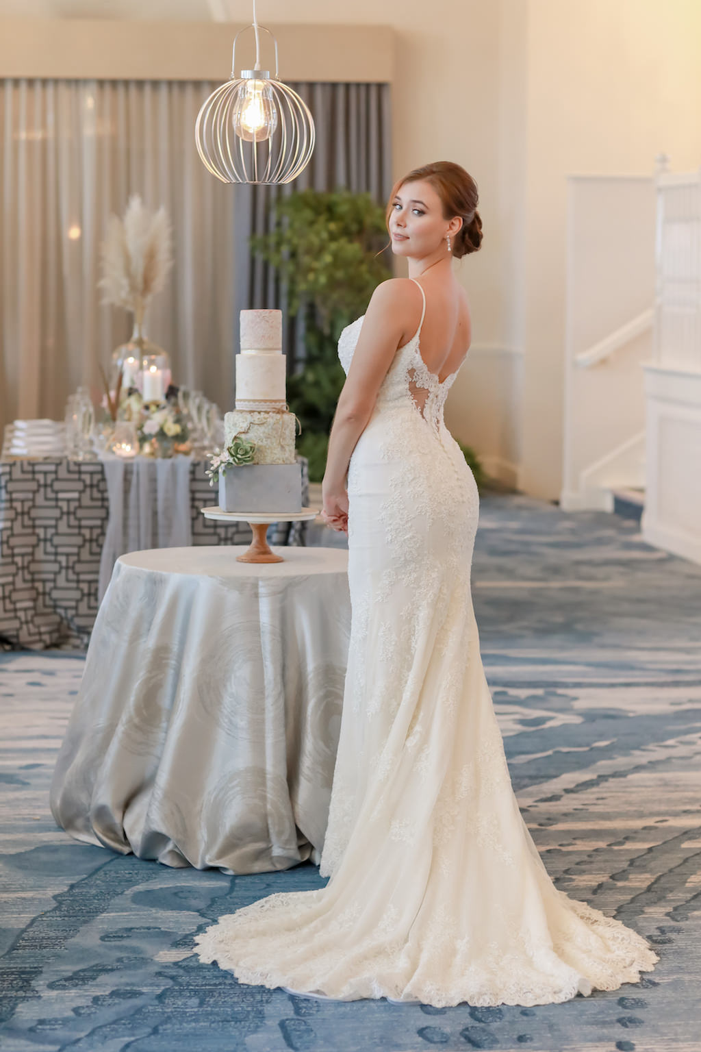 Bride Portrait in Fitted Lace and Strap Wedding Dress with Lace and Button Back, Four Tier White and Blue Wedding Cake on Round Table with Silver Tablecloth | St. Petersburg Photographer Lifelong Photography Studios | Tampa Bay Wedding Dress Shop Truly Forever Bridal | St. Petersburg Historic Hotel Ballroom The Don Cesar | Cake The Artistic Whisk | Rentals Over the Top Rental Linens