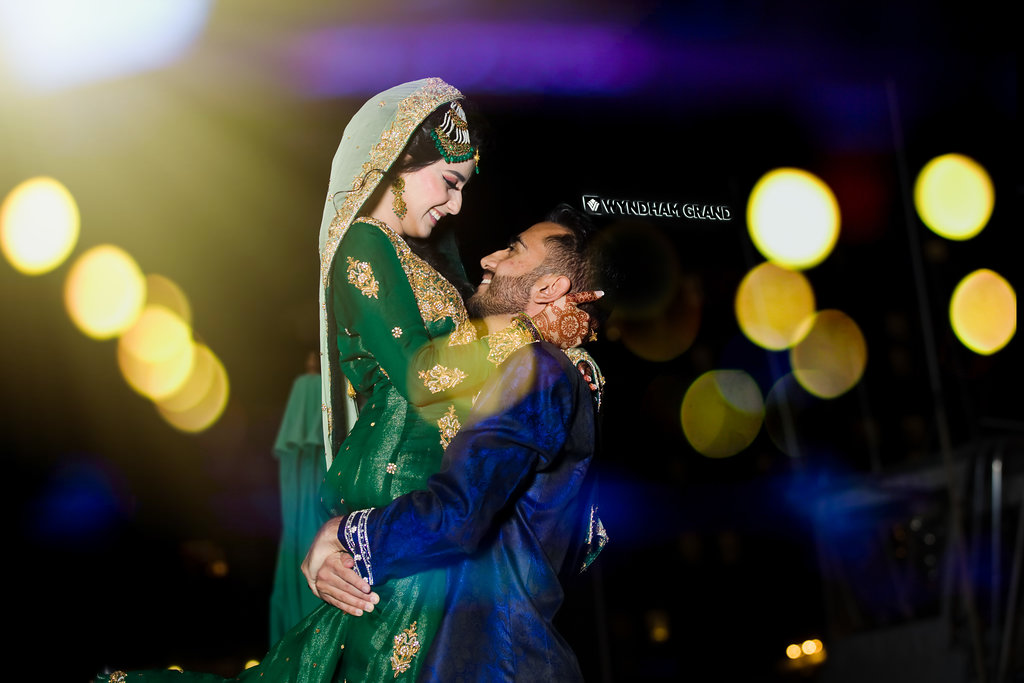 Traditional Indian Bride and Groom Wedding Portrait, Bride in Traditional Green and Gold Sari with Henna Tattoo, Groom in Traditional Blue and White Attire | Tampa Bay Wedding Venue Wyndham Grand Clearwater Beach