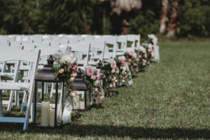 Garden Style Outdoor Sarasota Wedding Ceremony Decor, White Wooden Folding Chairs, Black Lanterns with Candles and Organic Blush Pink, Dusty Pink, Ivory and Greenery Florals
