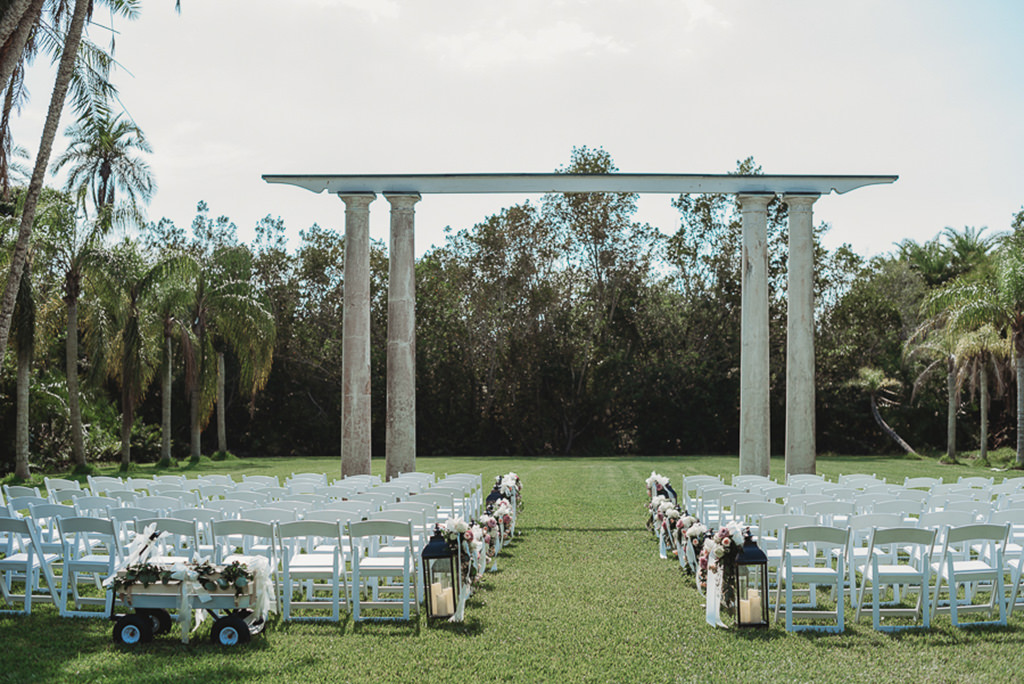 Garden Style Outdoor Florida Wedding Ceremony Decor, White Wooden Folding Chairs, Black Lanterns with Candles and Organic Blush Pink, Dusty Pink, Ivory and Greenery Florals, Pillar Style Canopy