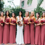 St. Petersburg Bride and Bridesmaid Outdoor Wedding Portrait, Bride in Romantic Fitted Lace and Illusion Deep V-Neck Pnina Tornai Wedding Dress and Garden Inspired Blush Pink, White, Red and Greenery Floral Bouquet, Bridesmaids in Matching Strapless Dusty Rose Dresses with Red Floral Bouquets | Tampa Bay Bridesmaids Dresses Bella Bridesmaids | St. Petersburg Wedding Planner Parties A'la Carte