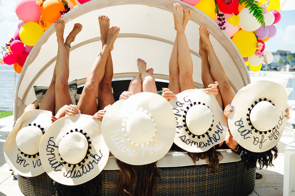 Tampa Bay Bachelorette Party in Personalized Hats in Cabana with Colorful Balloon Arch with Florals | Tampa Bay Wedding Venue The Godfrey Hotel | Photographer Grind and Press Photography