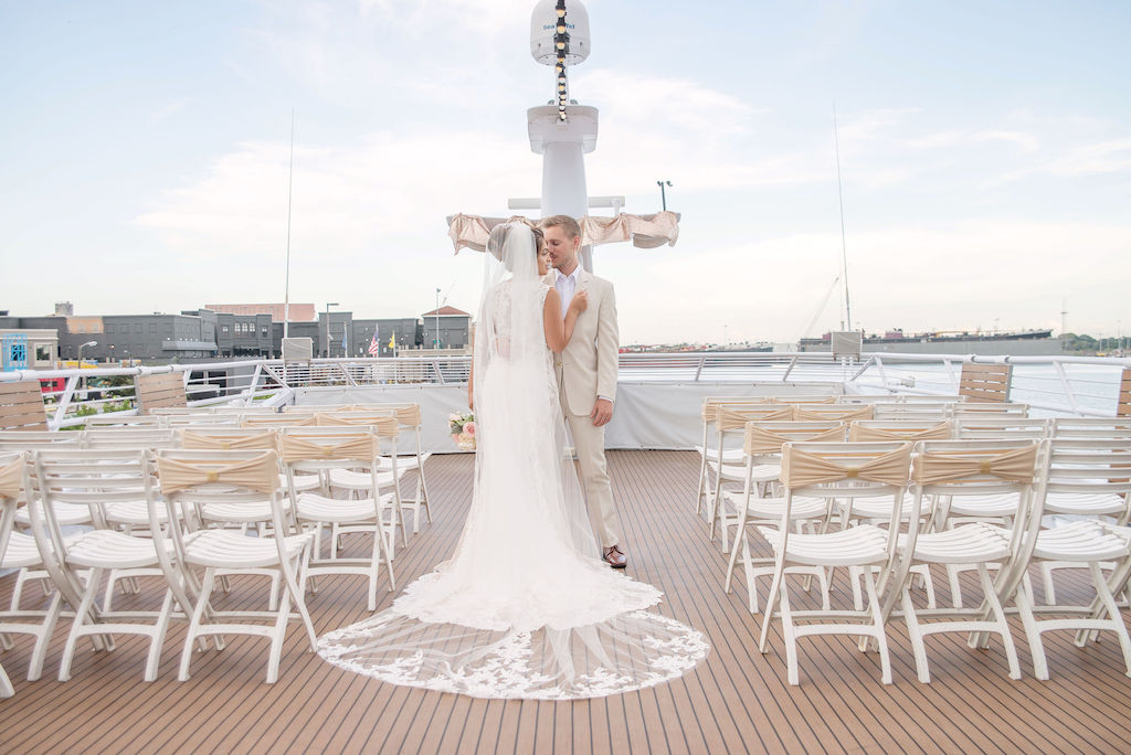 Florida Bride Wedding Portrait on Deck of Yacht, White Folding Chairs with Champagne Sashes, Bride in Cathedral Length Lace and Tulle Veil | Tampa Bay Wedding Photographer Kristen Marie Photography | Wedding Dress and Veil Nikki's Glitz and Glam Boutique | Tampa Waterfront Venue Yacht Starship II