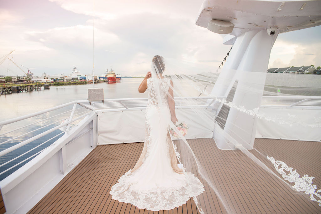 Florida Bride Wedding Portrait on Deck of Yacht, White Folding Chairs with Champagne Sashes, Bride in Cathedral Length Lace and Tulle Veil | Tampa Bay Wedding Photographer Kristen Marie Photography | Wedding Dress and Veil Nikki's Glitz and Glam Boutique | Tampa Waterfront Venue Yacht Starship II