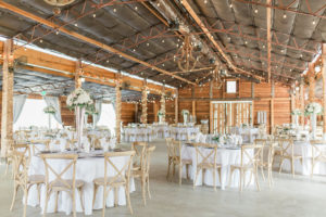 Rustic Elegant Tampa Bay Barn Wedding Reception Decor, Round Tables with Grey Tablecloths, Wood Chiavari Chairs, Low and Tall Floral Centerpieces and Hanging String Lights | Plant City Wedding Venue Florida Rustic Barn Weddings