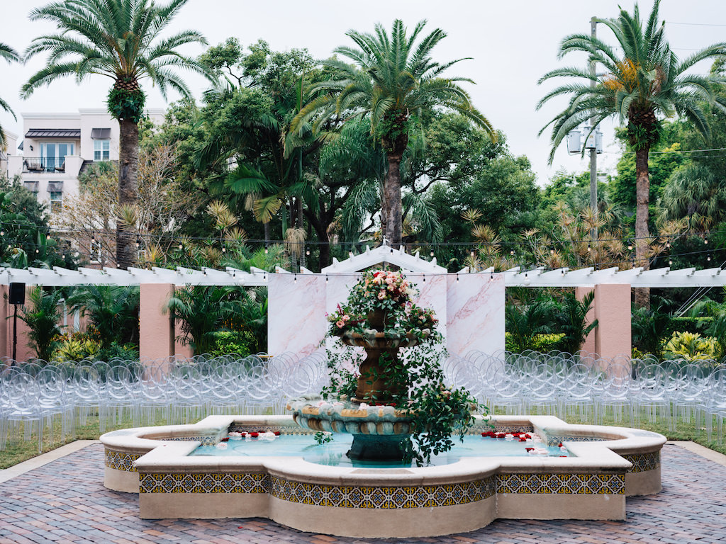 Elegant Outdoor Courtyard Wedding Ceremony Decor, Fountain with Greenery and Blush Pink Florals Cascading, Clear Acrylic Chairs | Tampa Bay Wedding Planner Parties A'la Carte | St. Petersburg Hotel Wedding Venue The Vinoy Renaissance
