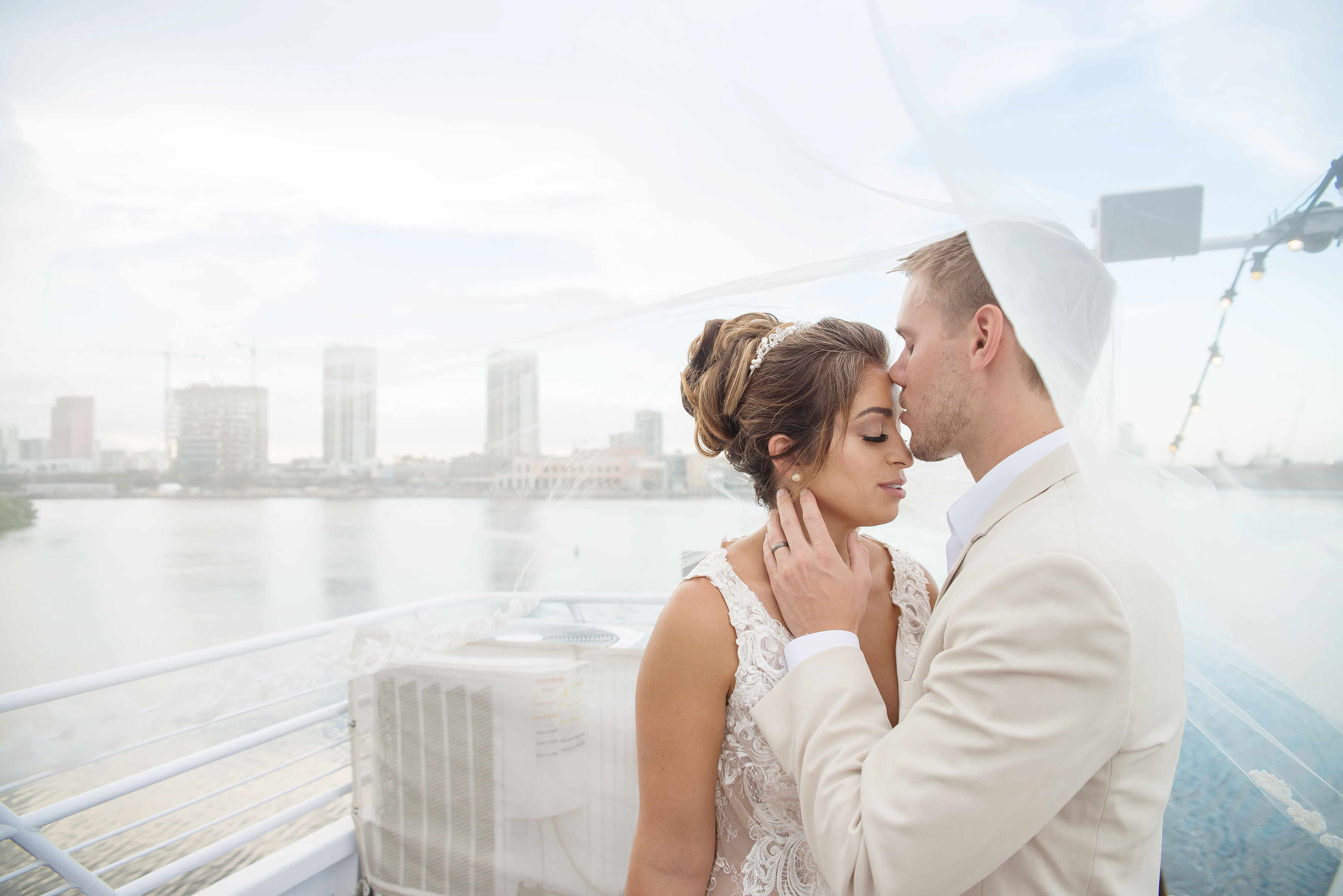 Creative Florida Bride and Groom Under Veil Wedding Portrait on Deck of Yacht | Tampa Bay Wedding Photographer Kristen Marie Photography | Tampa Waterfront Venue Yacht Starship II | Wedding Dress and Veil Nikki's Glitz and Glam Boutique | Menswear Sacinos Formalwear | Hair and Makeup Destiny and Light Hair and Makeup Group