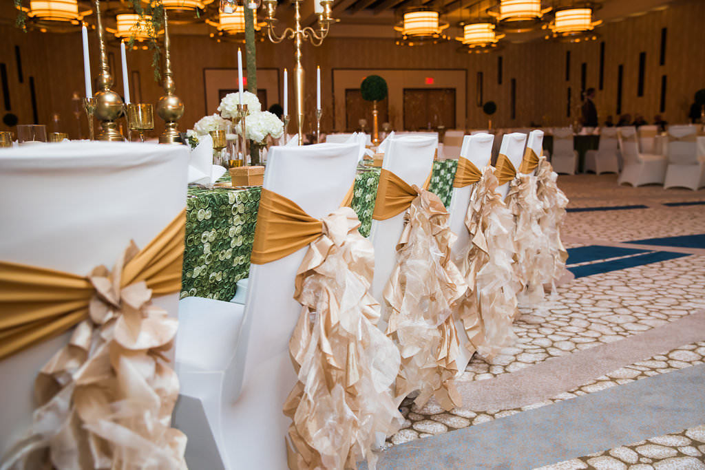 Glamorous Traditional Indian Wedding Hotel Ballroom Reception Decor, Long Feasting Table, Green Decorative Tablecloth, Chairs with White Covers and Gold Sashes, Gold Candlesticks Centerpieces | Tampa Bay Wedding Venue Wyndham Grand Clearwater Beach