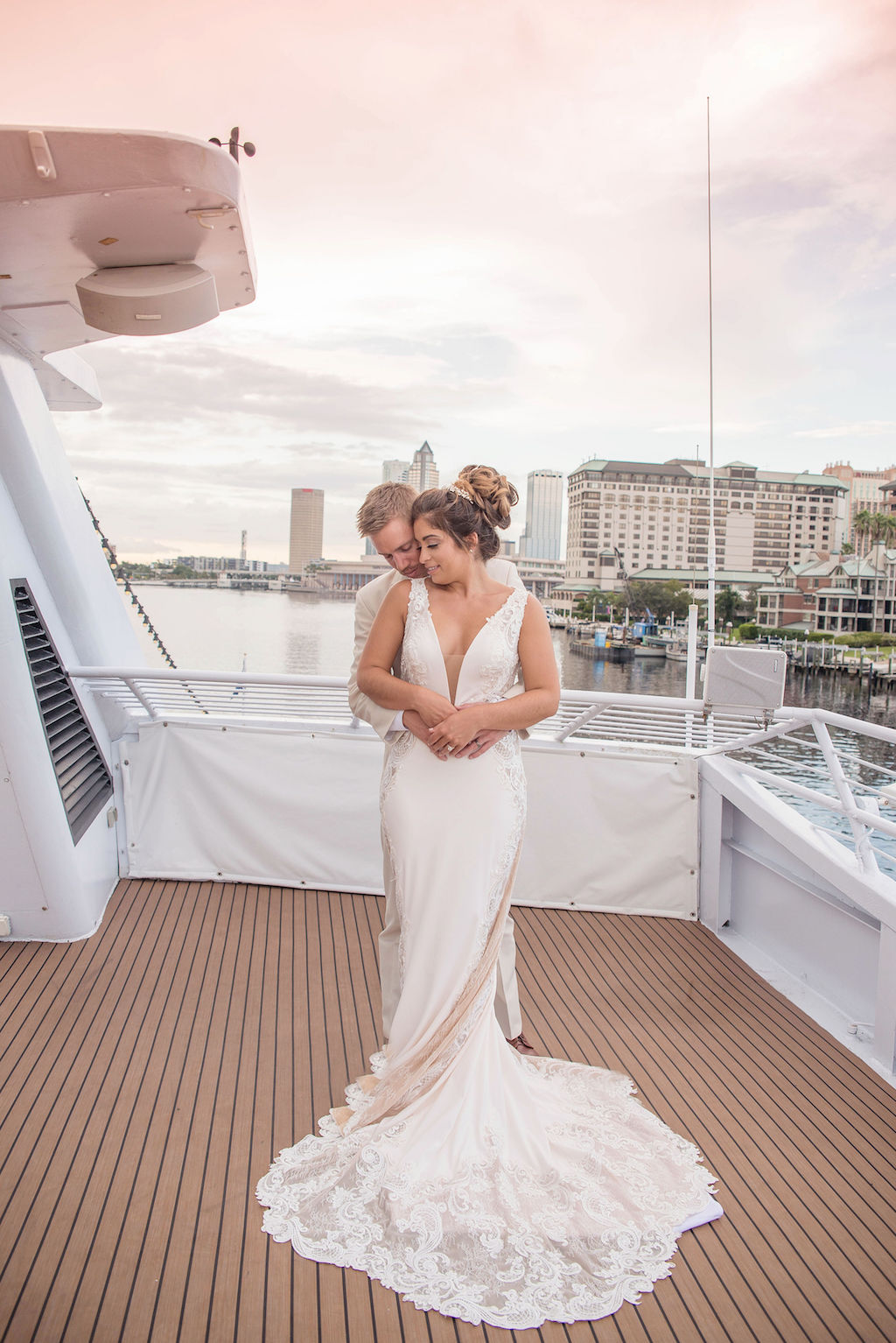 Florida Bride and Groom Sunset Wedding Portrait on Deck of Tampa Waterfront Venue Yacht Starship II, Bride in Deep V Neck Illusion Lace and Fitted Tank Top Strap Wedding Dress | Tampa Bay Wedding Photographer Kristen Marie Photography | Wedding Dress Nikki's Glitz and Glam Boutique | Hair and Makeup Destiny and Light Hair and Makeup Group
