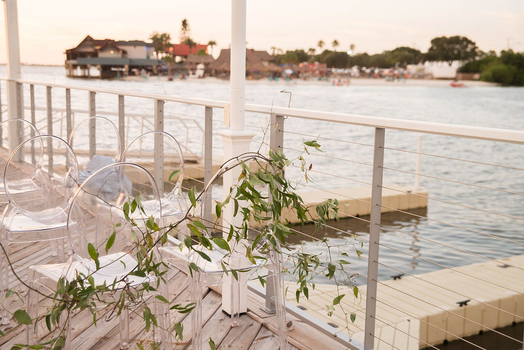 Florida Outdoor Waterfront Wedding Ceremony Decor, Clear Acrylic Chairs and Greenery Garland | Tampa Wedding Photographer Kristen Marie Photography | Tampa Wedding Venue The Godfrey | Rentals Gabro Event Services