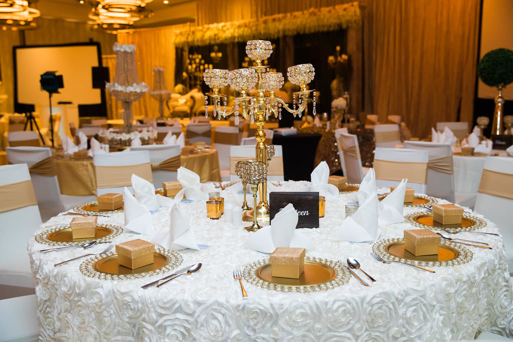 Glamorous Traditional Indian Wedding Hotel Ballroom Ceremony Decor, White Rose Tablecloth, Gold Chargers with Gold Boxes, Tall Gold Chandelier Candlestick Centerpiece | Tampa Bay Wedding Venue Wyndham Grand Clearwater Beach