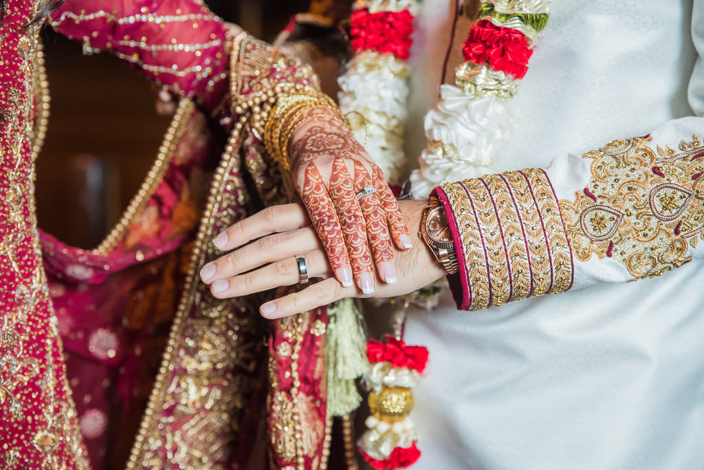 Glamorous Traditional Indian Bride and Groom Wedding Portrait, Bride in Red and Gold Sari with Henna Tattoo, Groom in White and Red Traditional Attire