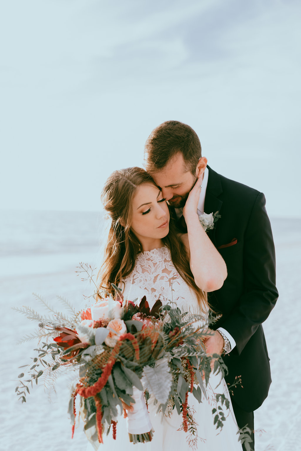 Beach Waterfront Bride and Groom Wedding Portrait with Wild Organic Red, Burgundy, Blush Pink and Greenery Floral Bouquet, Bride in Lace and Illusion High Neck Wedding Dress | St. Petersburg Wedding Venue Postcard Inn on the Beach | Tampa Bay Hair and Makeup Artist Michele Renee the Studio