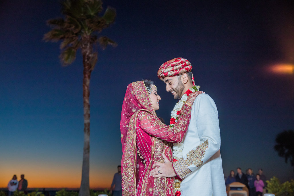 Glamorous Traditional Indian Bride and Groom Wedding Portrait, Bride in Red and Gold Sari with Henna Tattoo, Groom in White and Red Traditional Attire and Red and Gold Turban