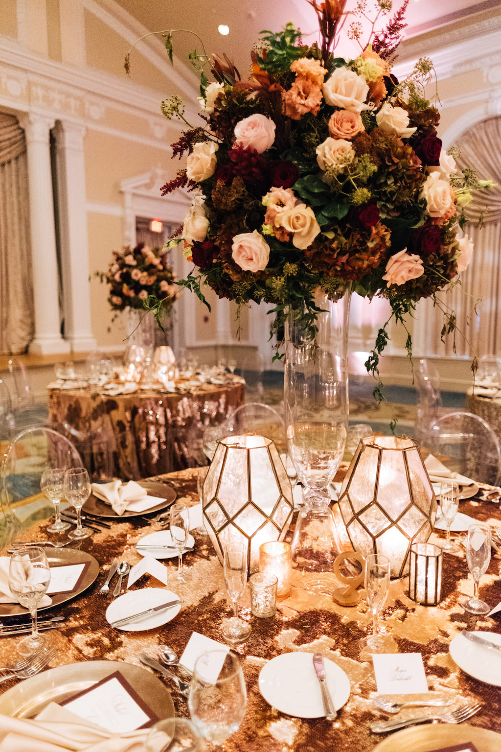 Elegant, Romantic Hotel Ballroom Wedding Reception Decor, Round Table with Gold Sequin Tablecloth, Tall Glass Vase with Burgundy, Blush Pink, Ivory and Greenery Floral Bouquet Centerpiece, White and Gold Geometric Candle Vases | Tampa Bay Wedding Planner Parties A'la Carte | St. Petersburg Hotel Wedding Venue The Vinoy Renaissance