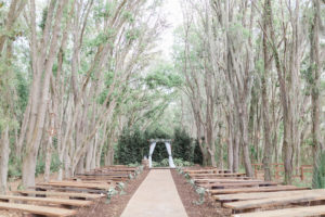Rustic Elegant Wedding Tampa Bay Ceremony Outdoors, Wooden Benches, Wooden Arch with White Linen Draping and Greenery | Plant City Wedding Venue Florida Rustic Barn Weddings