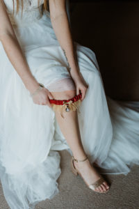 Bride Getting Ready Portrait Putting on Garnet and Gold Florida State University Themed Garter, Gold Sparkle Peep Toe Strappy Wedding Shoes